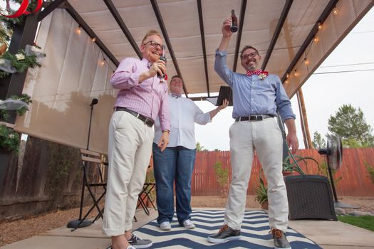 Minister with male gay couple celebrating their marriage