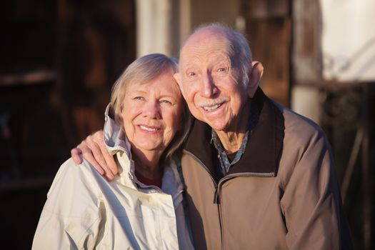 Cute elderly Caucasian couple in jackets smiling outdoors