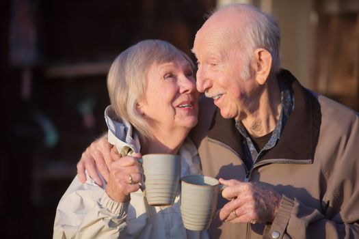 Happy senior woman with coffee kissing husband
