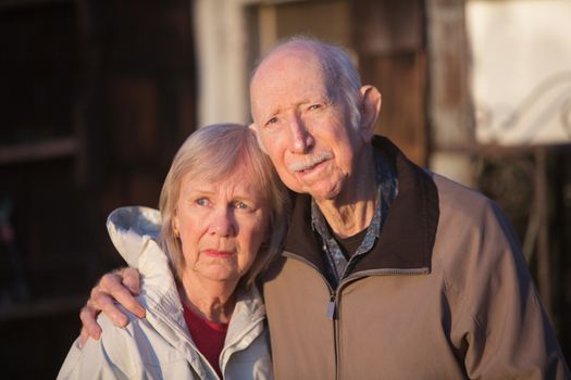 Serious European senior couple standing together outdoors