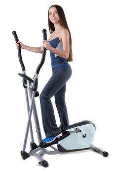young cute sporty woman doing exercises with elliptical trainer, on white background