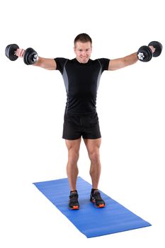 young man fitness instructor shows finishing position of standing dumbbell lateral raise, isolated on white