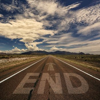 Conceptual image of desert road with the word end and arrow