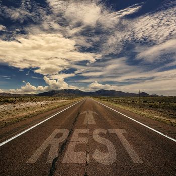 Conceptual image of desert road with the word rest and arrow