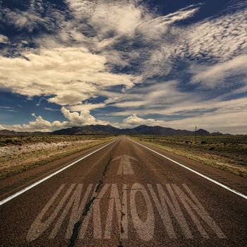 Conceptual image of desert road with the word unknown and arrow