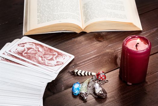 Composition of esoteric objects,candle,cards and book used for healing and fortune-telling.