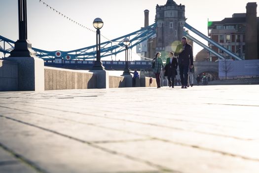 early morning with people commuting to work near tower bridge in London