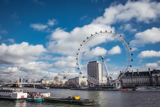 London, United Kingdom - 19 February, 2014: Beautiful day with cumulus clouds overlooking river thames and London eye. At 135m, the EDF Energy London Eye is the world’s largest cantilevered observation wheel.