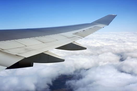 Wing of the plane on a background of clouds