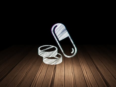 Healthcare concept: Glowing Pills icon in grunge dark room with Wooden Floor, black background