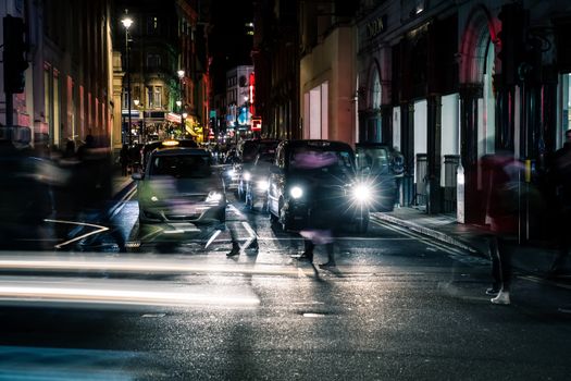 London, United Kingdom - 22 February, 2014: London's traffic at night with blurres and light streams of public transport near piccadilly circus.