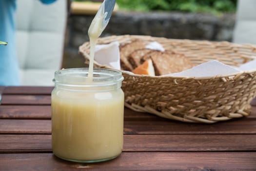 breakfast with honey. using a knife to get honey out of jar