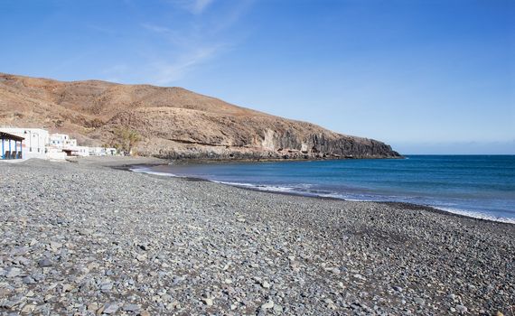 Beach with pebbles in the small fishing village of Giniginamar on the south east coast of Fuerteventura, Canary Islands, Spain.