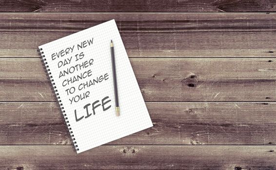 Inspirational quote on notepad.
EVERY NEW
 DAY IS 
ANOTHER 
CHANCE 
TO CHANGE 
YOUR LIFE.