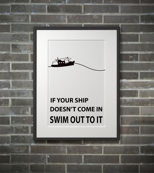 Inspirational quote on picture frame over a dirty brick wall. IF YOUR SHIP DOESN'T COME IN SWIM OUY TO IT.