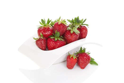 Delicious ripe strawberries in white bowl isolated on white background. Healthy fruit eating.