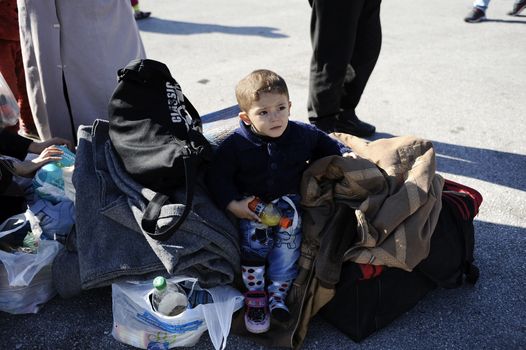 GREECE, Port of Piraeus: A young refugee takes a seat shortly after arriving at the Port of Piraeus near Athens, Greece on November 6, 2015. Two ferries have just arrived from Mytilene and Chios carrying roughly 3,000 migrants. The latest influx has brought tens of thousands of people seeking new lives in Europe after fleeing from the instability in the Middle East and northern Africa.
