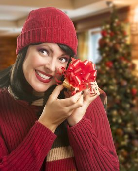 Happy Woman Holding Wrapped Gift in Christmas Setting.