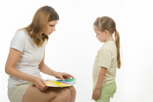 girl shows girl pictures with flowers, and the girl said what color the pictures