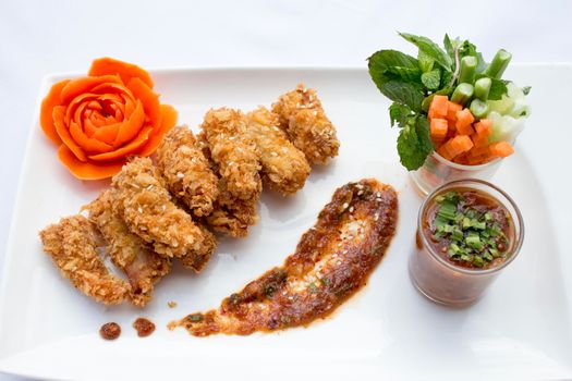 Tasty fried chicken and vegetable in white plates on white background .