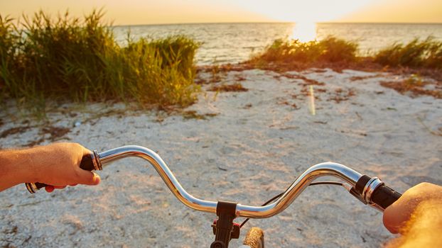 the hands holding handlebar of a bicycle