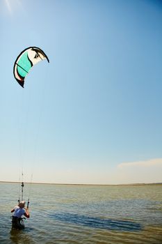 A young woman kite-surfer rides in summer day