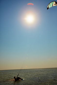 A young woman kite-surfer rides in summer day