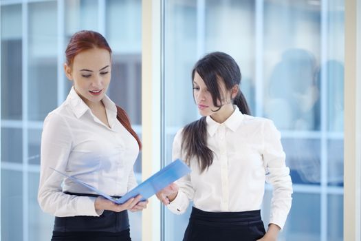 Two young beautiful businesswomen having meeting in modern office