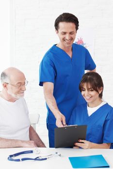 Happy senior patient and doctors in hospital