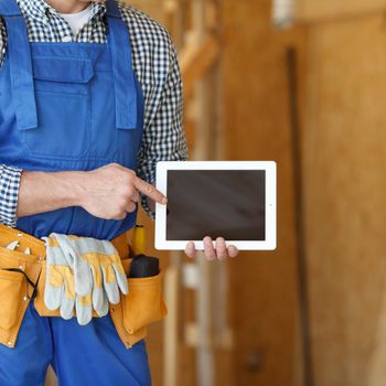 Construction worker pointing at digital tablet close-up