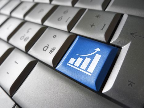 Positive business growth concept with growing bar graph and arrow icon and symbol on a blue laptop computer key for Internet and online business.