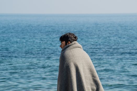 GREECE, Mytilene: A refugee looks out to the sea as he waits to depart from Mytilene, the capital and port city of the Greek island of Lesbos, on November 7, 2015. From there, thousands of refugees will make their way to the Port of Piraeus.