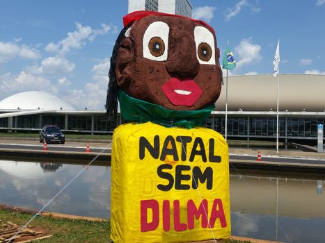 BRAZIL, Brasilia: A colorful sign is posted as protesters camp out beside Brazil's National Congress in Brasilia on November 7, 2015 as part of the movement to impeach President Dilma Rousseff. The sign, written in Portuguese, translates to: Christmas without Dilma, calling for Rousseff's impeachment before Christmas. Pressure has been mounting for congress to impeach Rousseff amid a struggling economy and corruption scandals.