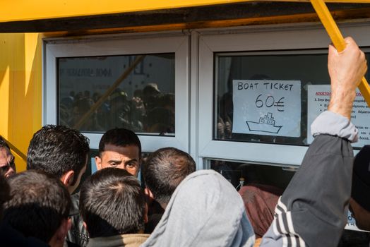 GREECE, Mytilene: Refugees purchase boat tickets before departing from Mytilene, the capital and port city of the Greek island of Lesbos, on November 7, 2015. From there, thousands of refugees will make their way to the Port of Piraeus.