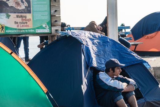 GREECE, Mytilene: A refugee sits in his tent as he waits to depart from Mytilene, the capital and port city of the Greek island of Lesbos, on November 7, 2015. From there, thousands of refugees will make their way to the Port of Piraeus.