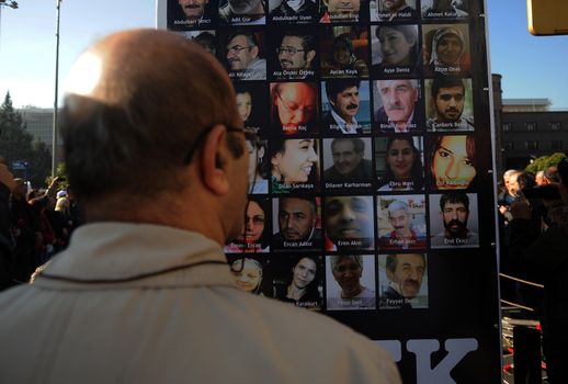 TURKEY, Ankara: A man looks upon a sign bearing the faces of victims of the October 10 bombings during a ceremony in Ankara, Turkey on November 7, 2015, honoring the victims. The twin explosions left at least 97 people dead and more than 400 others injured on October 10.