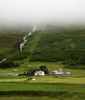 Farm houses and waterfall on backgroud,Iceland