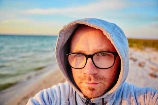 Handsome man with glasses making selfie and smiling