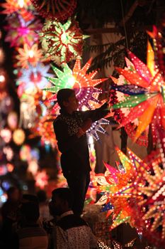 Pune, India - November 7, 2015: A man arranging sky lanterns in his streetside shop on the occasion of diwali festival in India