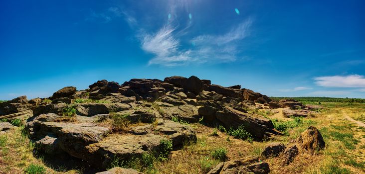 Stone range Kamyana Mohyla. The site encompasses a group of isolated blocks of sandstone, up to twelve meters in height, scattered around an area of some 3,000 square meters. As Noghai legend has it, it resulted from a scuffle of two baghaturs who took turns throwing rocks at each other. In truth, the site had its origins in a sandbank of the Tethys Ocean. For a long time it was an island in the Molochna River, which has since been silted up and now flows a short distance to the west. It is thought to represent the only sandstone outcrop in the Azov-Kuban Depression.