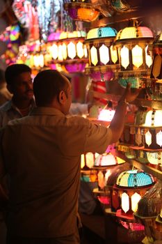 Pune, India - November 7, 2015: A streetside shopkeeper showing sky lanterns to a customer on the occasion of Diwali festival in India