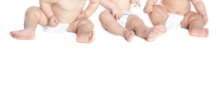 Three toddlers in diaper on a white background