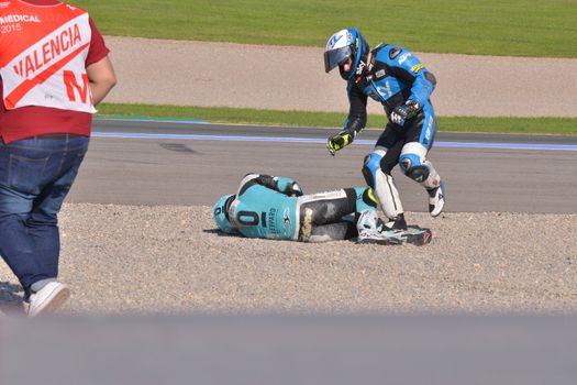 SPAIN, Cheste: Spanish pilot Efren Vasquez (C) lays on the floor after a fall with  Romano Frenatti (R) during Valencia Motor GP tournament at Ricardo Tormo circuit in Valencia, Spain on November 8, 2015.Miguel Oliveira won the race and Danny Kent took Moto3 title.
