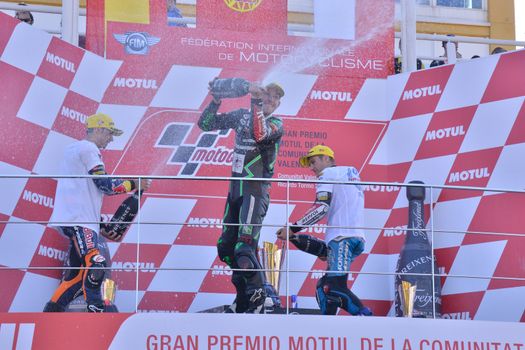 SPAIN, Cheste: Red Bull KTM Ajo's Portugese rider Miguel Oliveira (R), Sepang International Circuit's Czech rider Jakub Kornfeil (C) and Estrella Galicia 0,0's Sapnish rider Jorge Navarro celebrate on the podium after the Moto3 race at the Valencia Grand Prix at Ricardo Tormo racetrack in Cheste, near Valencia on November 8, 2015.
