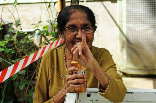 MYANMAR, Yangon: A woman shows her inked finger after casting her ballot at a polling station in Yangon. Myanmar goes to the polls in an historic election that could thrust opposition leader Aung San Suu Kyi's pro-democracy party into power and pull the country away from the grip of the military. 