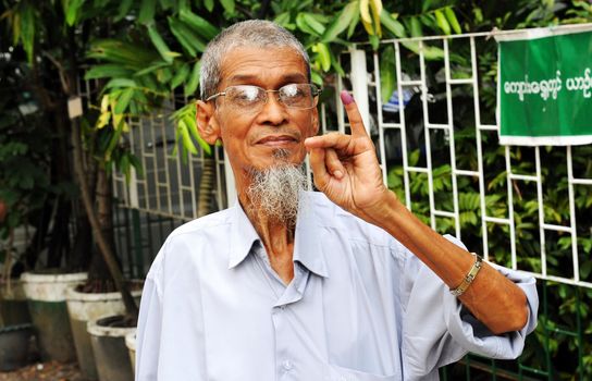 MYANMAR, Yangon: A man shows his inked figer after casting his ballot at a polling station in Yangon, on November 8, 2015. Myanmar goes to the polls in an historic election that could thrust opposition leader Aung San Suu Kyi's pro-democracy party into power and pull the country away from the grip of the military. 