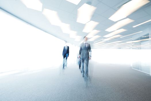 Abstract blurry portrait of walking businessman in office