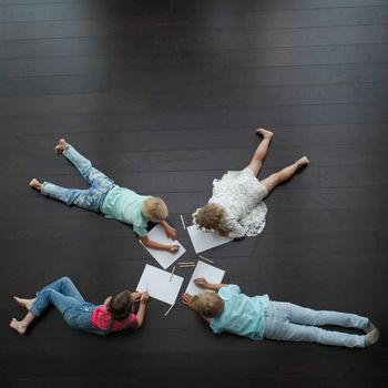 Group of cute children drawing with colorful pencils on floor