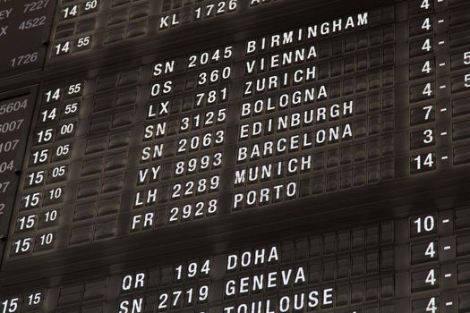 Airport departure board in terminal with flight information