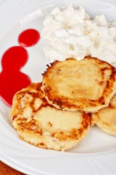 Cheese pancakes with sour cream and berry jam